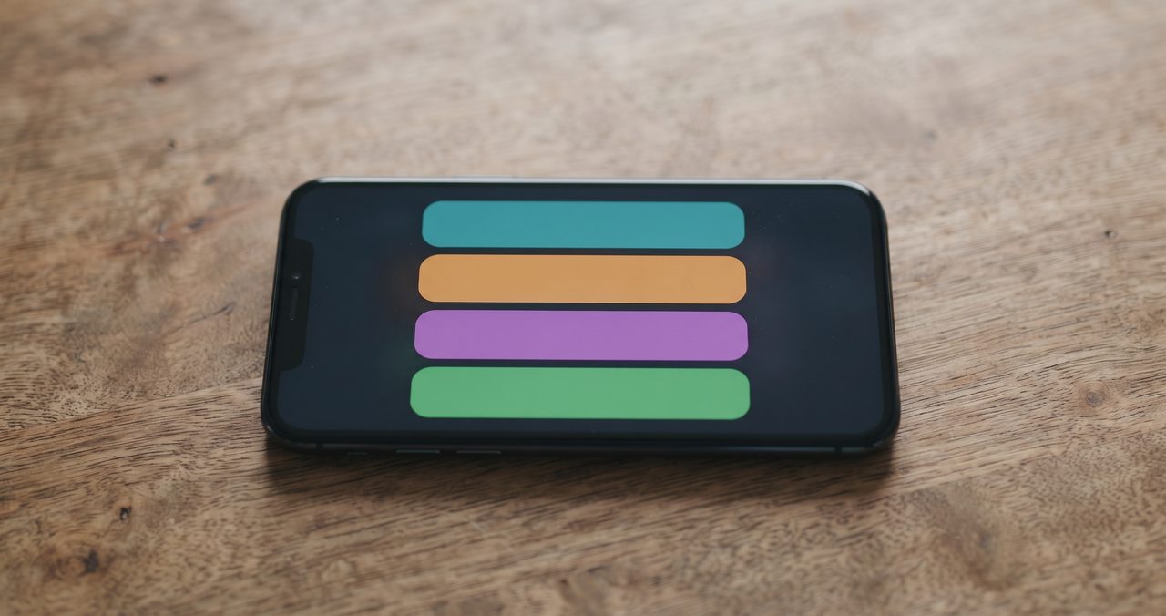 木目調のテーブルに置かれたスマートフォンの画面に、複数の通知が上下に重なって表示されている様子